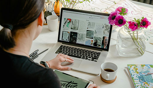 Woman working on a laptop at home, with home comforts surrounding her