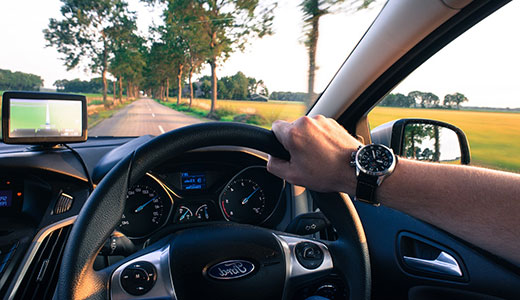 Interior of a car showing drivers hand on the steering wheel