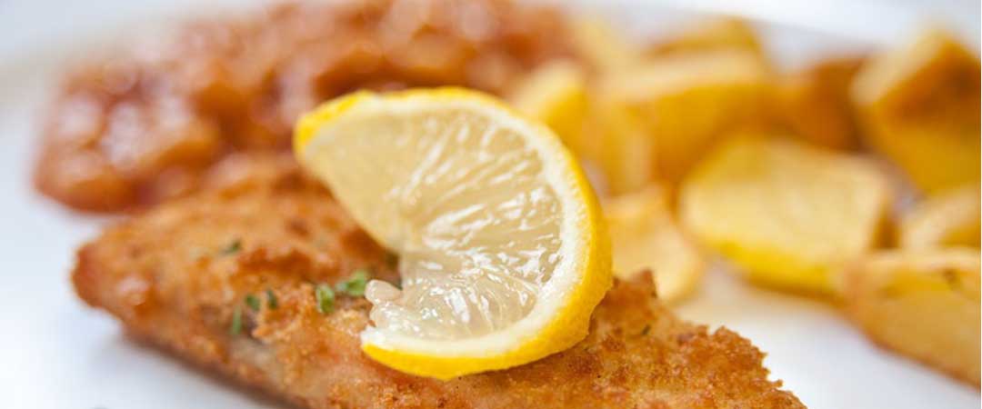 Battered Pollock served with chips, peas and bread and spread