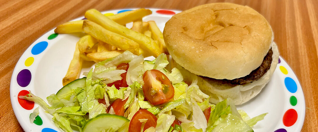 Beefburger in a bun served with chips, baked beans or salad