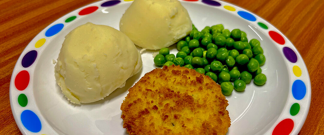 Cod and salmon fishcake served with mashed potato and baked beans or vegetables