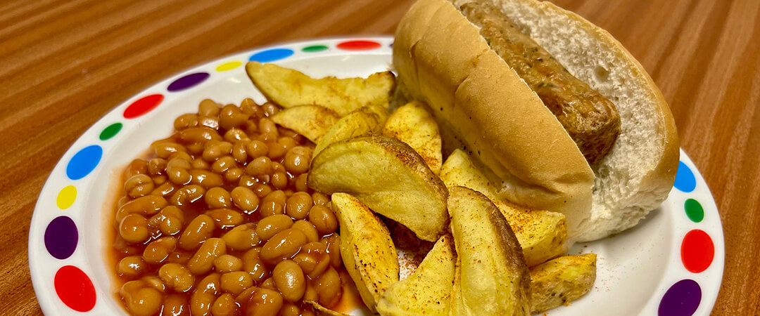 Hotdog served with BBQ wedges and baked beans