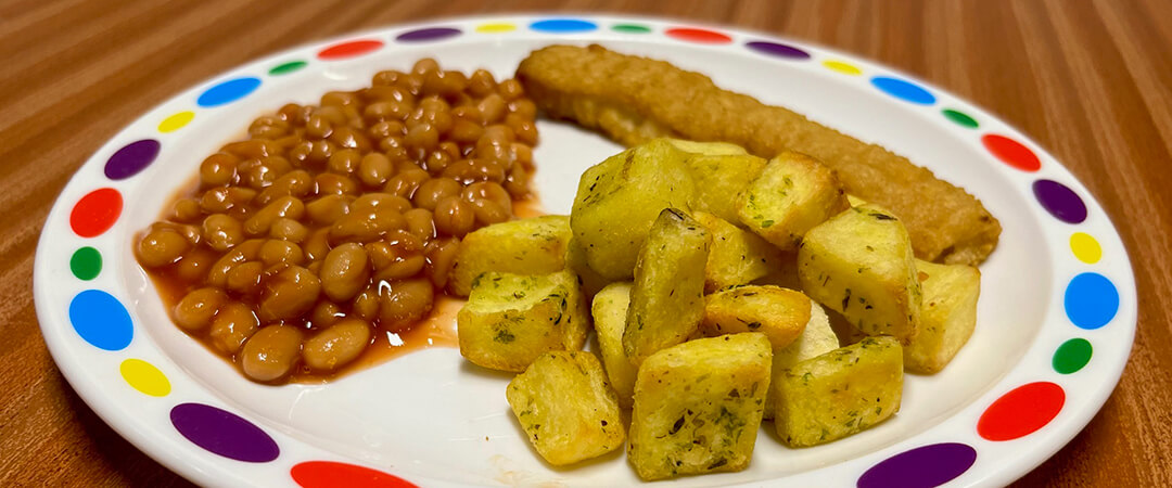 Jumbo fish finger served with herby diced potatoes, baked beans or peas and bread and spread