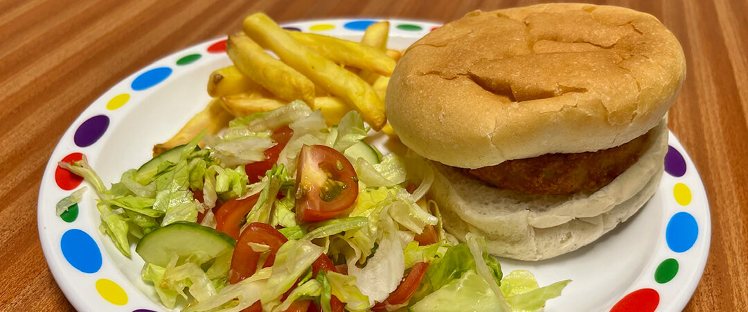 Vegetarian burger (Ve) in a bun served with chips, baked beans or salad