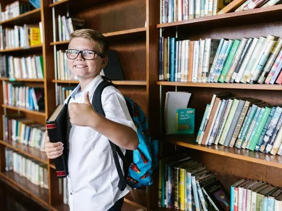 A boy in the library with his thumbs up (Pexles - RDNE Stock project)