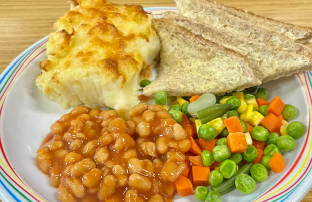 Cheese and potato pie served with mixed vegetables, broccoli, gravy and bread and spread