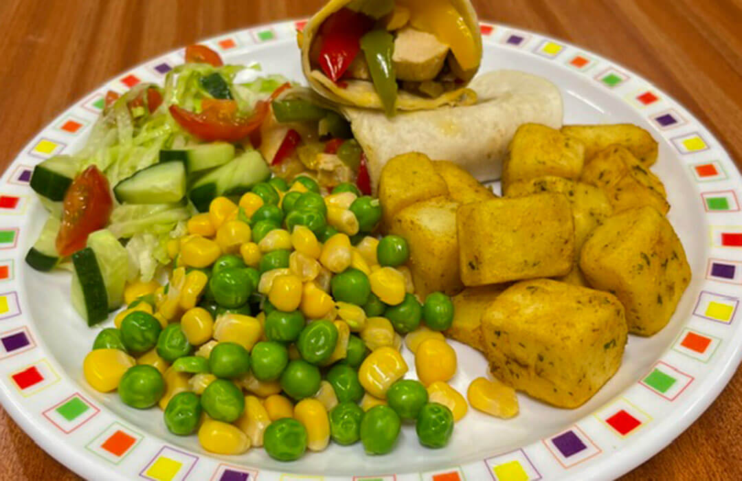 Mediterranean fajitas served with herby diced potatoes, peas and sweetcorn or baked beans