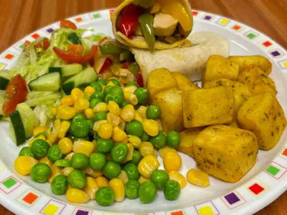 Mediterranean fajitas served with herby diced potatoes, peas and sweetcorn or baked beans