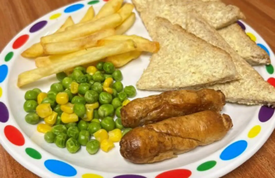 Quorn sausage (Ve) in a roll or bread and spread served with chips, peas and sweetcorn or baked beans