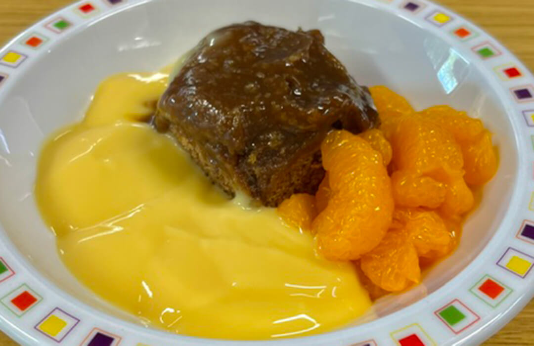 Sticky toffee pudding with fruit and custard