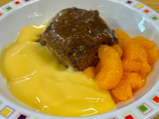 Sticky toffee pudding with fruit and custard