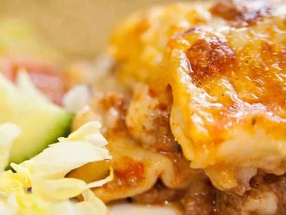 Homemade lasagne served with garlic bread and salad
