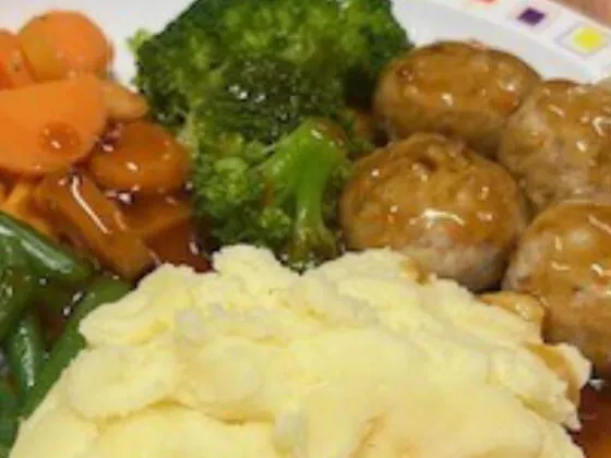 Pork and carrot meatballs in gravy served with mashed potato, broccoli, carrots, green beans and gravy