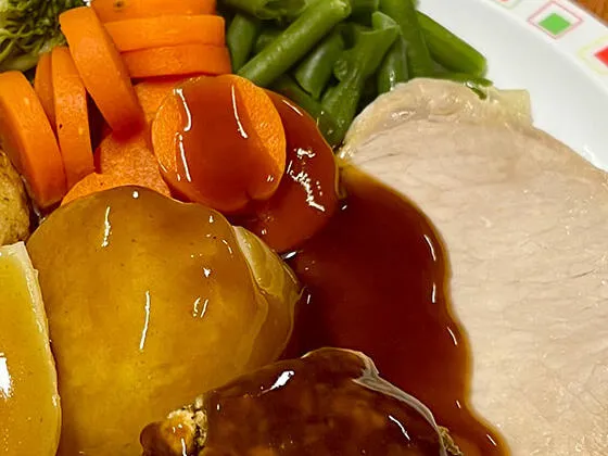 Pork loin served with roast and boiled potatoes, veg selection and gravy