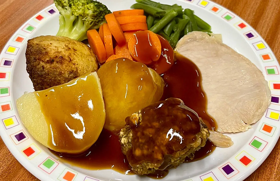 Pork loin served with roast and boiled potatoes, veg selection and gravy