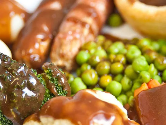 Pork Sausages with Yorkshire Pudding, Roast and Boiled Potatoes, Vegetables and Gravy
