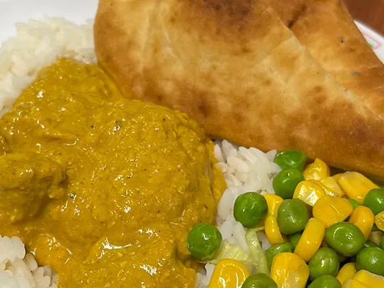 Quorn and vegetable curry served with rice, peas and sweetcorn and Naan bread