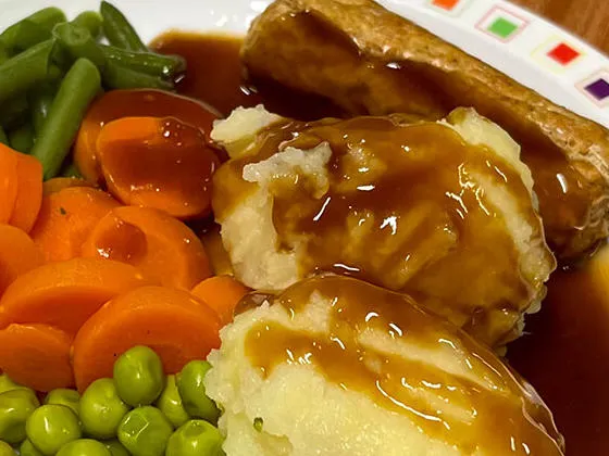 Quorn sausage (Ve) served with stuffing, seasonal vegetables, roast and boiled potatoes and gravy