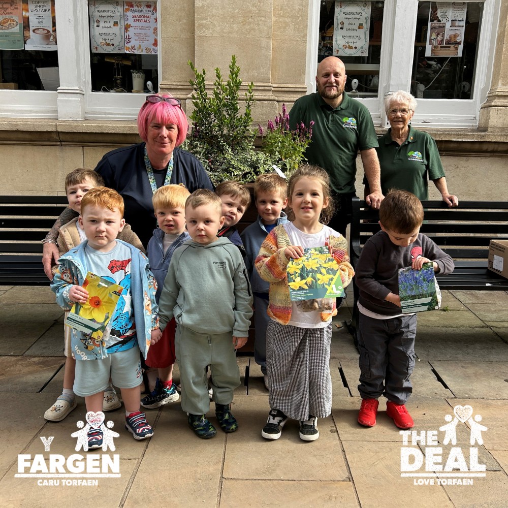 Children from Osbourne Lodge Nursery planting bulbs in the town centre
