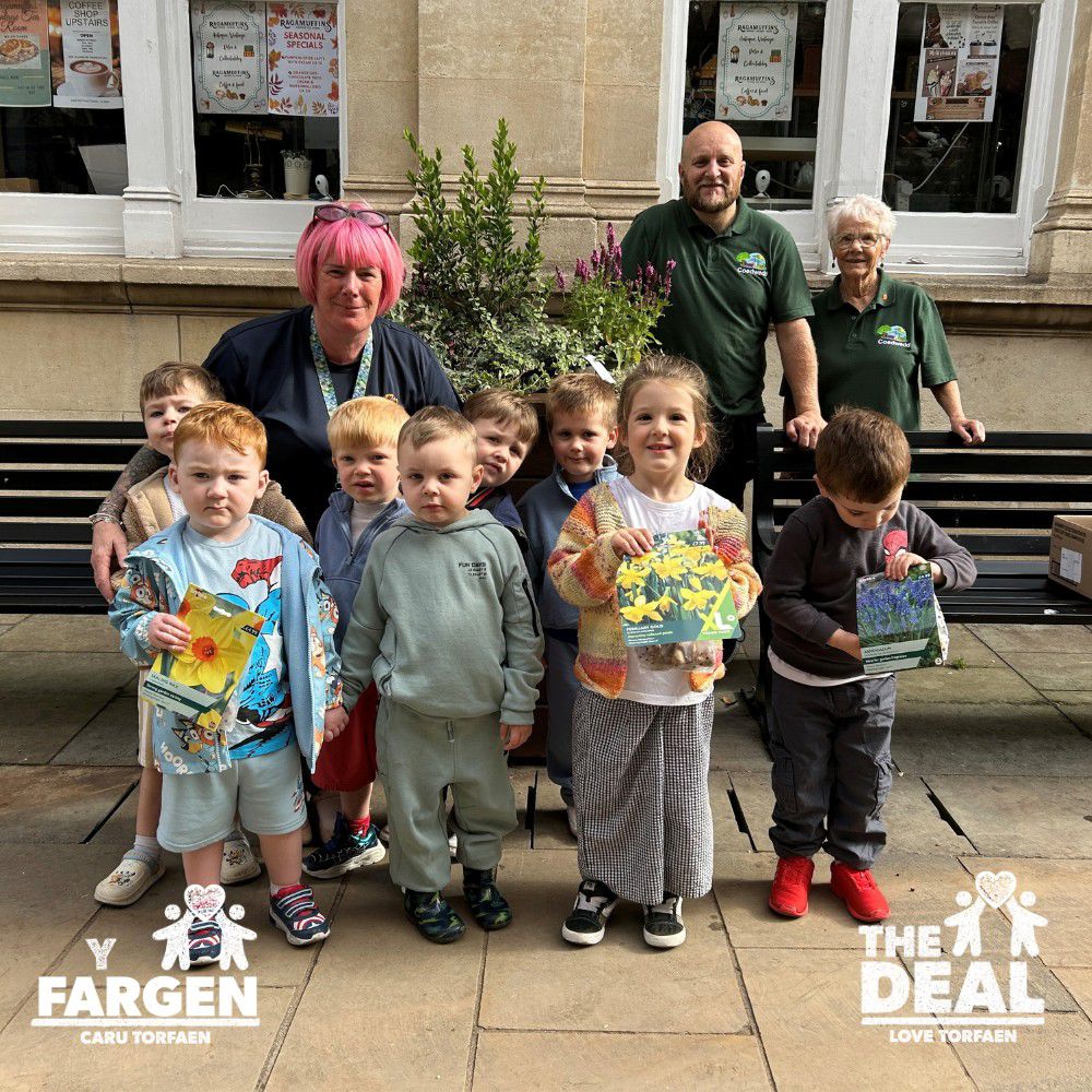 Children from Osbourne Lodge Nursery planting bulbs in the town centre