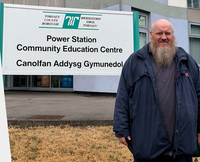 Anthony standing out side the power station smiling  