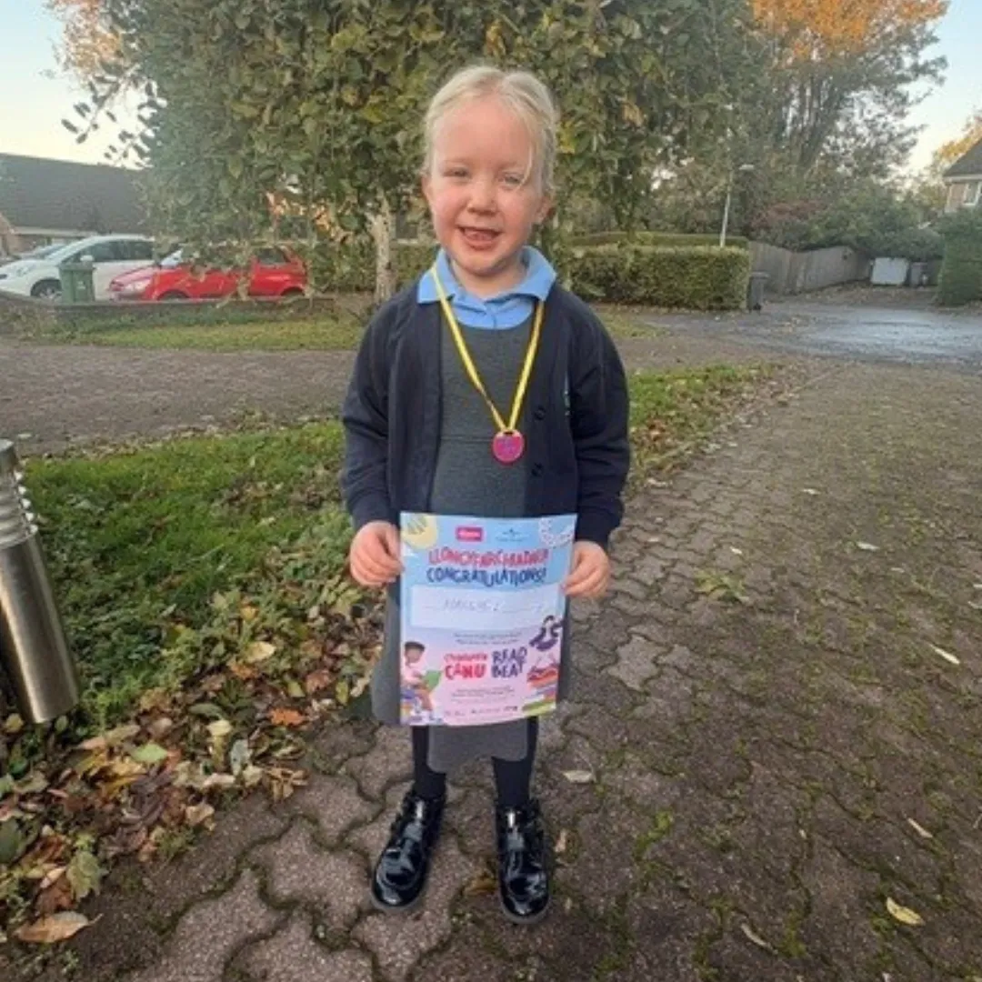 Year 1 pupil Hallie holding a certificate